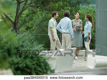 Casually dressed young executives standing outdoors, talking View Large Photo Image Stock Photography - Casually dressed young executives standing outdoors, talking. Fotosearch