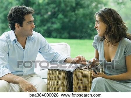 Man and woman sitting in arm chairs outdoors, talking View Large Photo Image Stock Photo - Man and woman sitting in arm chairs outdoors, talking. Fotosearch