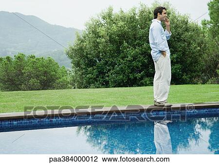 Man using cell phone by edge of pool View Large Photo Image Stock Image - Man using cell phone by edge of pool. Fotosearch