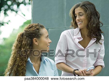 Two women, talking outdoors View Large Photo Image Stock Photo - Two women, talking outdoors. Fotosearch