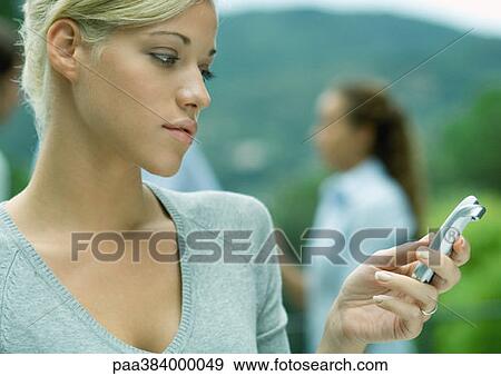 Stock Photo - Woman looking at cell phone. Fotosearch