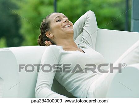 Stock Photo - Woman lounging in armchair. Fotosearch
