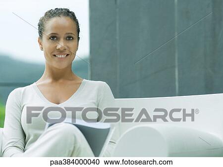 Woman sitting in armchair, outdoors, smiling View Large Photo Image Stock Image - Woman sitting in armchair, outdoors, smiling. Fotosearch