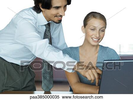 Businessman helping female colleague with computer View Large Photo Image Stock Photography - Businessman helping female colleague with computer. Fotosearch