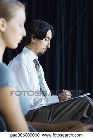 Businessman sitting, taking notes View Large Photo Image Stock Image - Businessman sitting, taking notes. Fotosearch
