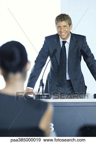Businessman standing next to microphone in seminar View Large Photo Image Stock Photo - Businessman standing next to microphone in seminar. Fotosearch