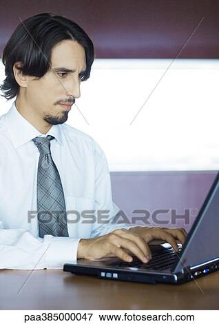 Stock Photo - Businessman using laptop, portrait. Fotosearch