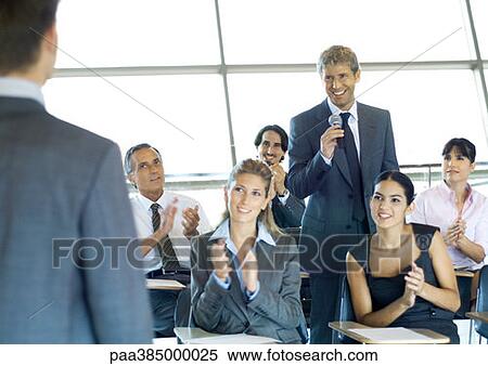 Executives in seminar, one man holding microphone, others clapping View Large Photo Image Stock Photography - Executives in seminar, one man holding microphone, others clapping. Fotosearch
