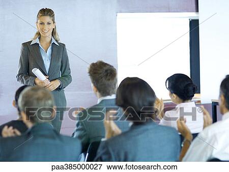 Executives sitting in seminar, woman standing facing group View Large Photo Image Stock Photo - Executives sitting in seminar, woman standing facing group. Fotosearch