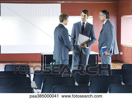 Executives standing, speaking in conference room View Large Photo Image Stock Image - Executives standing, speaking in conference room. Fotosearch