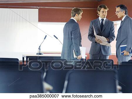 Executives standing, speaking in conference room View Large Photo Image Stock Photo - Executives standing, speaking in conference room. Fotosearch