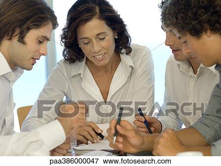 Stock Photo - Business associates looking at document together. Fotosearch