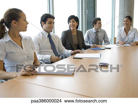 Business associates sitting at conference table View Large Photo Image Picture - Business associates sitting at conference table. Fotosearch