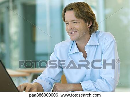 Businessman using laptop computer, smiling View Large Photo Image Stock Photograph - Businessman using laptop computer, smiling. Fotosearch