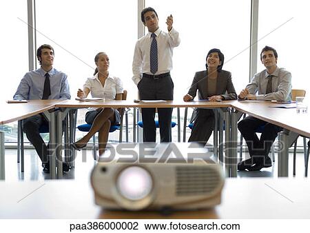 Businesspeople watching presentation, videoprojector in foreground View Large Photo Image Stock Image - Businesspeople watching presentation, videoprojector in foreground. Fotosearch