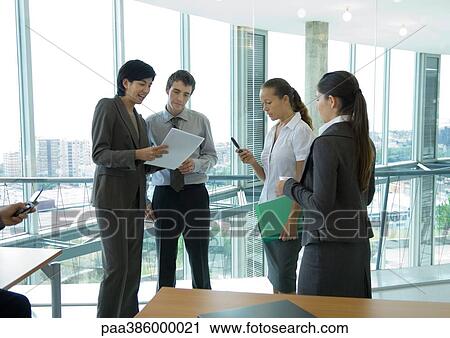 Four office workers standing, talking View Large Photo Image Stock Image - Four office workers standing, talking. Fotosearch