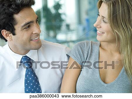 Male and female office workers smiling at each other View Large Photo Image Stock Image - Male and female office workers smiling at each other. Fotosearch
