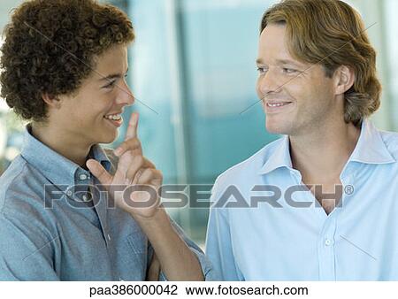 Two office workers, smiling at each other View Large Photo Image Stock Image - Two office workers, smiling at each other. Fotosearch