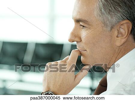 Stock Photography - Man sitting in airport lounge, close-up of face. Fotosearch