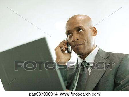 Man using laptop and cell phone View Large Photo Image Picture - Man using laptop and cell phone. Fotosearch