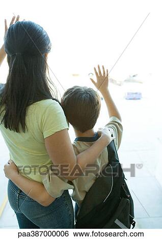Mother and boy looking out airport window, waving View Large Photo Image Stock Photograph - Mother and boy looking out airport window, waving. Fotosearch