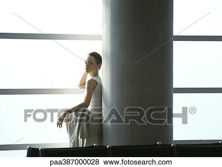 Woman leaning against column in airport View Large Photo Image Stock Photo - Woman leaning against column in airport. Fotosearch