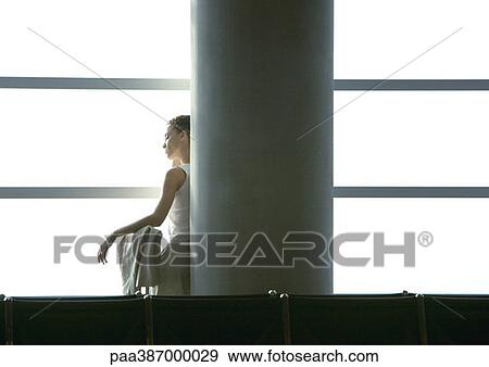 Woman leaning against column in airport View Large Photo Image Stock Photo - Woman leaning against column in airport. Fotosearch