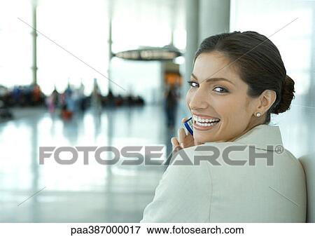 Woman looking over shoulder at camera, in airport View Large Photo Image Stock Photo - Woman looking over shoulder at camera, in airport. Fotosearch