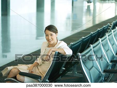 Stock Image - Woman sitting in airport lounge. Fotosearch