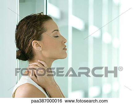 Stock Photograph - Woman with eyes closed and hand on neck. Fotosearch
