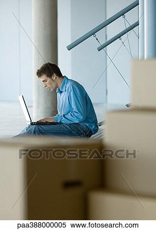 Businessman using laptop, cardboard boxes in foreground View Large Photo Image Stock Photography - Businessman using laptop, cardboard boxes in foreground. Fotosearch