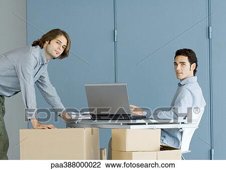 Businessmen working at table top supported by cardboard boxes View Large Photo Image Stock Image - Businessmen working at table top supported by cardboard boxes. Fotosearch