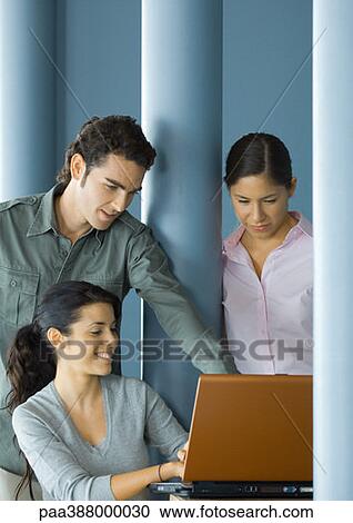 Three young adults using laptop computer together View Large Photo Image Stock Image - Three young adults using laptop computer together. Fotosearch