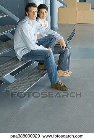 Two young business professionals sitting on stairs, cardboard boxes in background View Large Photo Image Stock Photo - Two young business professionals sitting on stairs, cardboard boxes in background. Fotosearch