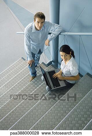 Stock Photo - Young business professionals posing on stairs, woman sitting with laptop computer. Fotosearch