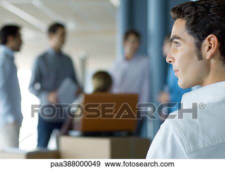 Young businessman, colleagues having meeting in background View Large Photo Image Stock Photo - Young businessman, colleagues having meeting in background. Fotosearch