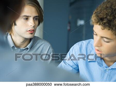 Young businessmen grouped in discussion, selective focus View Large Photo Image Stock Image - Young businessmen grouped in discussion, selective focus. Fotosearch