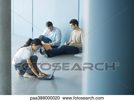 Young woman and two young men using laptops on floor View Large Photo Image Stock Image - Young woman and two young men using laptops on floor. Fotosearch