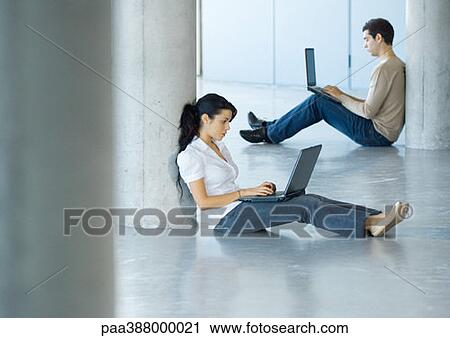 Young woman and young man sitting on floor, using laptops View Large Photo Image Stock Image - Young woman and young man sitting on floor, using laptops. Fotosearch