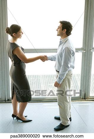 Businessman and businesswoman shaking hands, full length View Large Photo Image Stock Image - Businessman and businesswoman shaking hands, full length. Fotosearch
