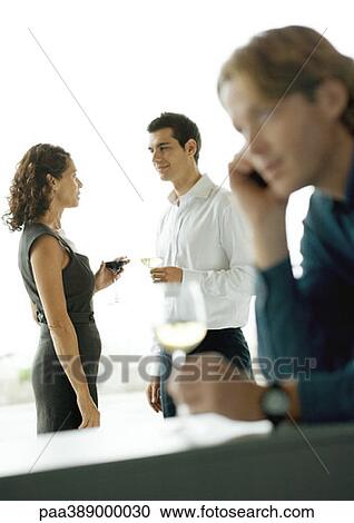 Cocktail party, focus on man and woman talking in background View Large Photo Image Stock Image - Cocktail party, focus on man and woman talking in background. Fotosearch