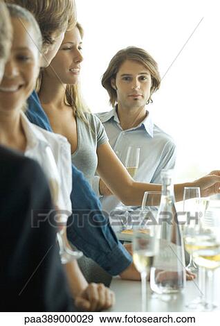 Group of young adults standing at bar, focus on man in background looking at camera View Large Photo Image Stock Photo - Group of young adults standing at bar, focus on man in background looking at camera. Fotosearch