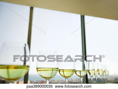 Stock Photography - Half-filled wine and champagne glasses lined up. Fotosearch