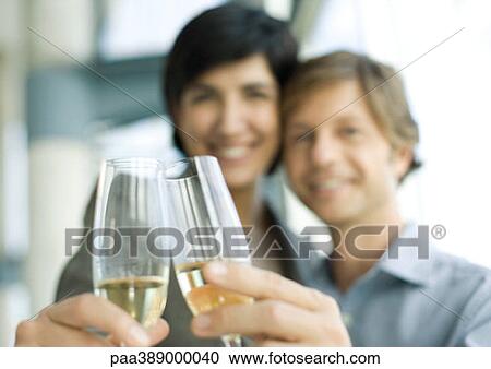 Man and woman clinking champagne glasses, focus on glasses in foreground View Large Photo Image Stock Image - Man and woman clinking champagne glasses, focus on glasses in foreground. Fotosearch