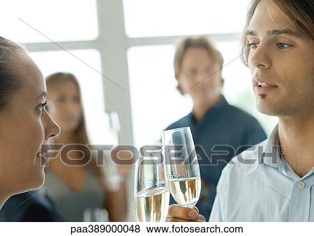 Man and woman clinking glasses during cocktail party View Large Photo Image Stock Photo - Man and woman clinking glasses during cocktail party. Fotosearch
