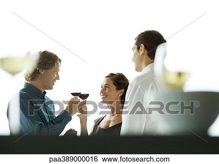 Man and woman clinking glasses during party View Large Photo Image Stock Photograph - Man and woman clinking glasses during party. Fotosearch