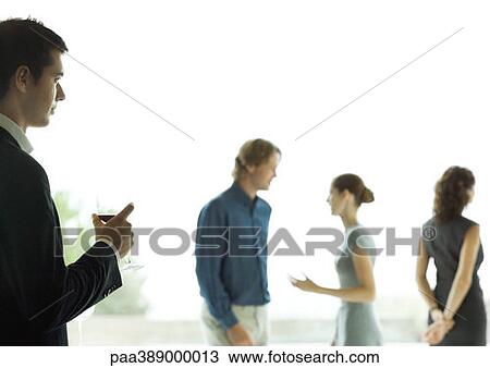 Man watching man and woman talk during cocktail party View Large Photo Image Stock Image - Man watching man and woman talk during cocktail party. Fotosearch
