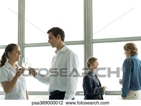 People talking during office party, holding glasses of champagne View Large Photo Image Stock Image - People talking during office party, holding glasses of champagne. Fotosearch