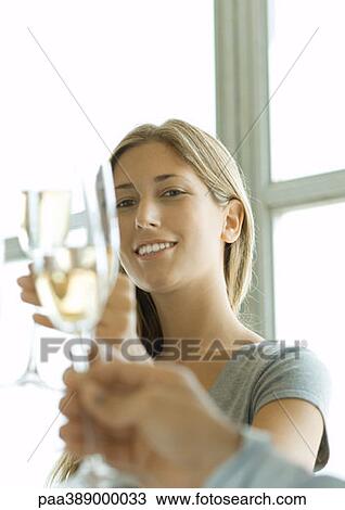 Woman clinking glass of chamagne, looking at camera View Large Photo Image Stock Image - Woman clinking glass of chamagne, looking at camera. Fotosearch