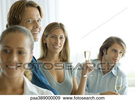 Stock Photo - Young adults drinking champagne at cocktail party. Fotosearch